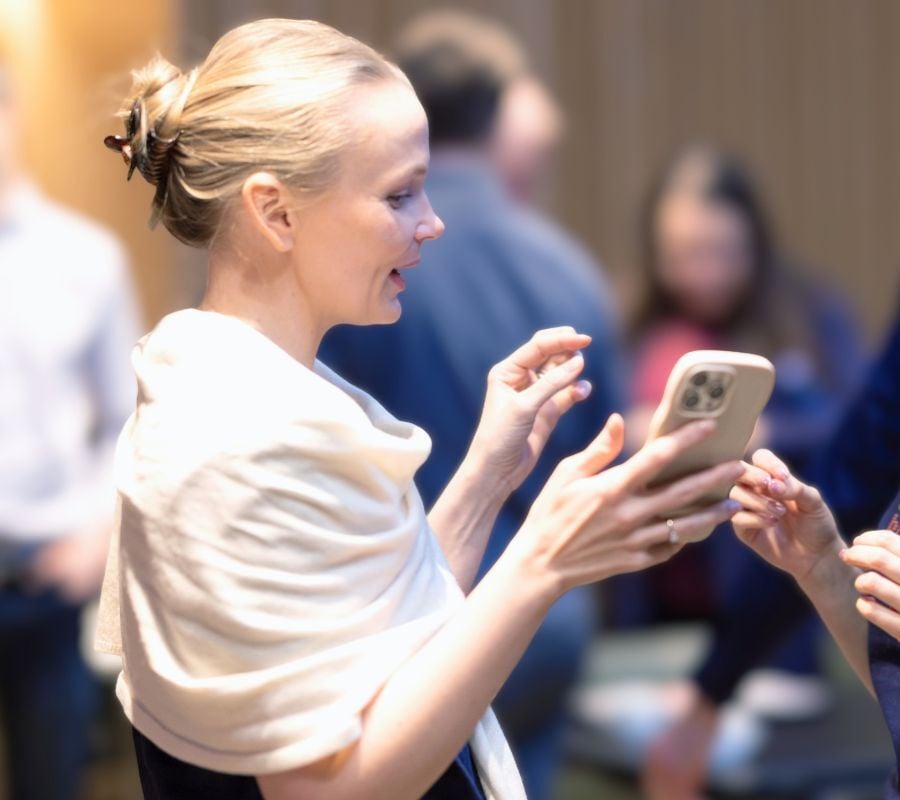 Användaren håller i en telefon för att symbolisera hur viktig CIAM (Customer Identity and Access Management) är som sammanbindande lager